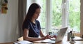 Woman accomplish work on laptop puts hands behind head relaxing