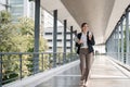 Young busy successful Asian business woman, professional businesswoman holding laptop and holding coffee cup standing or Royalty Free Stock Photo