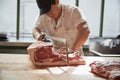 Young butcher sawing meat for sale at a butcher's shop Royalty Free Stock Photo