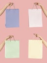 Young buyer holding paper shopping bags of pastel colors on pink background, closeup. Collage with empty space