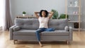 Calm black woman relaxing on comfortable sofa in living room Royalty Free Stock Photo