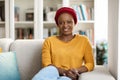 Young calm black woman relaxing on sofa in living room Royalty Free Stock Photo