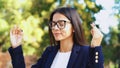 Young calm businesswoman relaxing, meditating at green park. Girl refuses stress and takes situation, calms down, breathes deeply Royalty Free Stock Photo