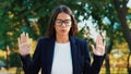 Young calm businesswoman relaxing, meditating at green park. Girl refuses stress and takes situation, calms down, breathes deeply Royalty Free Stock Photo