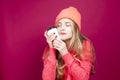 Young Calm Cheerful Caucasian Girl Laughing In Knitted Autumn Hat and Sweater With Cup of Coffee on Red Royalty Free Stock Photo