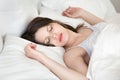 Young woman relaxing sleeping in cozy white bed Royalty Free Stock Photo