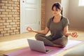 Young calm indian woman meditate watching online yoga class tutorial at home.