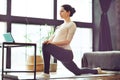 Young calm sporty pregnant woman doing yoga online at home through internet. Sport during pregnancy Royalty Free Stock Photo