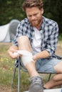 young camper bandaging wounded leg