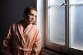 Young cancer patient standing in front of hospital window