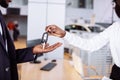 Sales situation in car dealership, young african couple gets the key for new car Royalty Free Stock Photo