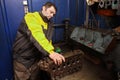 Young car mechanic cleans channels of the cylinder head engine. Royalty Free Stock Photo