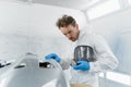 Young car painter working in a painting booth. Process of vehicle body repair in auto service. Royalty Free Stock Photo