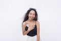 A young asian woman chuckles from a joke. A happy and lighthearted scene. on a white backdrop