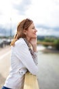 Young carefree woman thinking about love on bridge