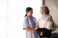 Young caregiver helping senior woman walking. Nurse assisting her old woman patient at nursing home. Senior woman with Royalty Free Stock Photo