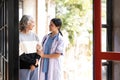 Young caregiver helping senior woman walking. Nurse assisting her old woman patient at nursing home. Senior woman with Royalty Free Stock Photo