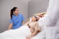 Young caregiver or nurse care and talking patient elderly on bed for consoling in room at hospital ward. Royalty Free Stock Photo