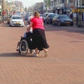 Young woman pushes an old lady in a wheelchair, Netherlands Royalty Free Stock Photo