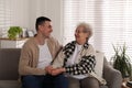 Young caregiver talking to senior woman in living room. Home health care service Royalty Free Stock Photo