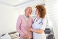 Young carer supporting senior disabled woman with walking stick. Portrait of happy female caregiver and senior woman walking Royalty Free Stock Photo