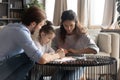 Adorable little kid girl enjoying creative activity with loving parents.