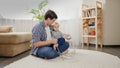 Young caring father teaching his baby son not to touch electric plugs, wires and cables at home. Royalty Free Stock Photo