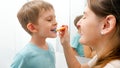 Young caring mother brushing and cleaning teeth of her little son. Parents and children taking care of teeth health and Royalty Free Stock Photo