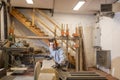 Young carpenter boy, concentrated on his job while cutting a long plank of wood with a circular saw Royalty Free Stock Photo