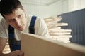 A young carpenter chooses a wooden board. Inspection and quality control of wood. Worker in the carpentry shop Royalty Free Stock Photo