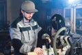 A young carpenter installs a wooden workpiece in a circular sawing machine. Home workshop. Novice businessman