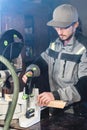 A young carpenter installs a wooden workpiece in a circular sawing machine. Home workshop. Novice businessman