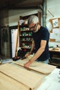 Young carpenter man manipulating wood sheets