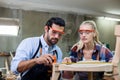 young carpenter man and women using measuring tape looking wood size at workspace. craftsman profession in wood factory Royalty Free Stock Photo