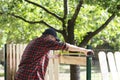 Young carpenter measuring wood using a tape measure  in the garden Royalty Free Stock Photo