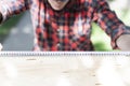 Young carpenter measuring wood using a tape measure  in the garden Royalty Free Stock Photo