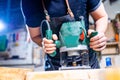 Young carpenter sawing board with circular saw Royalty Free Stock Photo