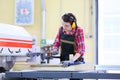 Young carpenter using sawing machine