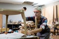 young carpenter women using measuring tape looking wood size at workspace. craftsman profession in wood factory Royalty Free Stock Photo