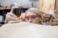 young carpenter women using measuring tape looking wood size at workspace. craftsman profession in wood factory Royalty Free Stock Photo