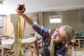 young carpenter women using measuring tape looking wood size at workspace. craftsman profession in wood factory. professional Royalty Free Stock Photo