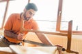 Young Carpenter working on wood with frame saw