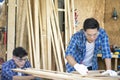 Young Carpentry workshop`s boss woodworking. Wood processing apprenticeship at carpentry shop Royalty Free Stock Photo