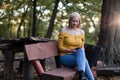 Young blonde woman listening to music on her phone in the park Royalty Free Stock Photo