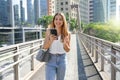 Brazilian woman watching her mobile phone walking in the city