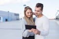 Young casual couple using tablet outdoors online shopping Royalty Free Stock Photo