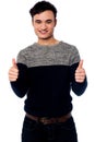 Young casual guy gesturing double thumbs up