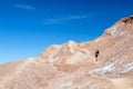 Young casual man with backpack on the path at moon like landscape of Valle de la Luna Moon valley, Chile