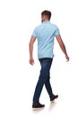 Young man in polo shirt walks and looks to side Royalty Free Stock Photo