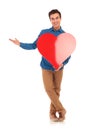 Young casual man holding big heart and presenting Royalty Free Stock Photo